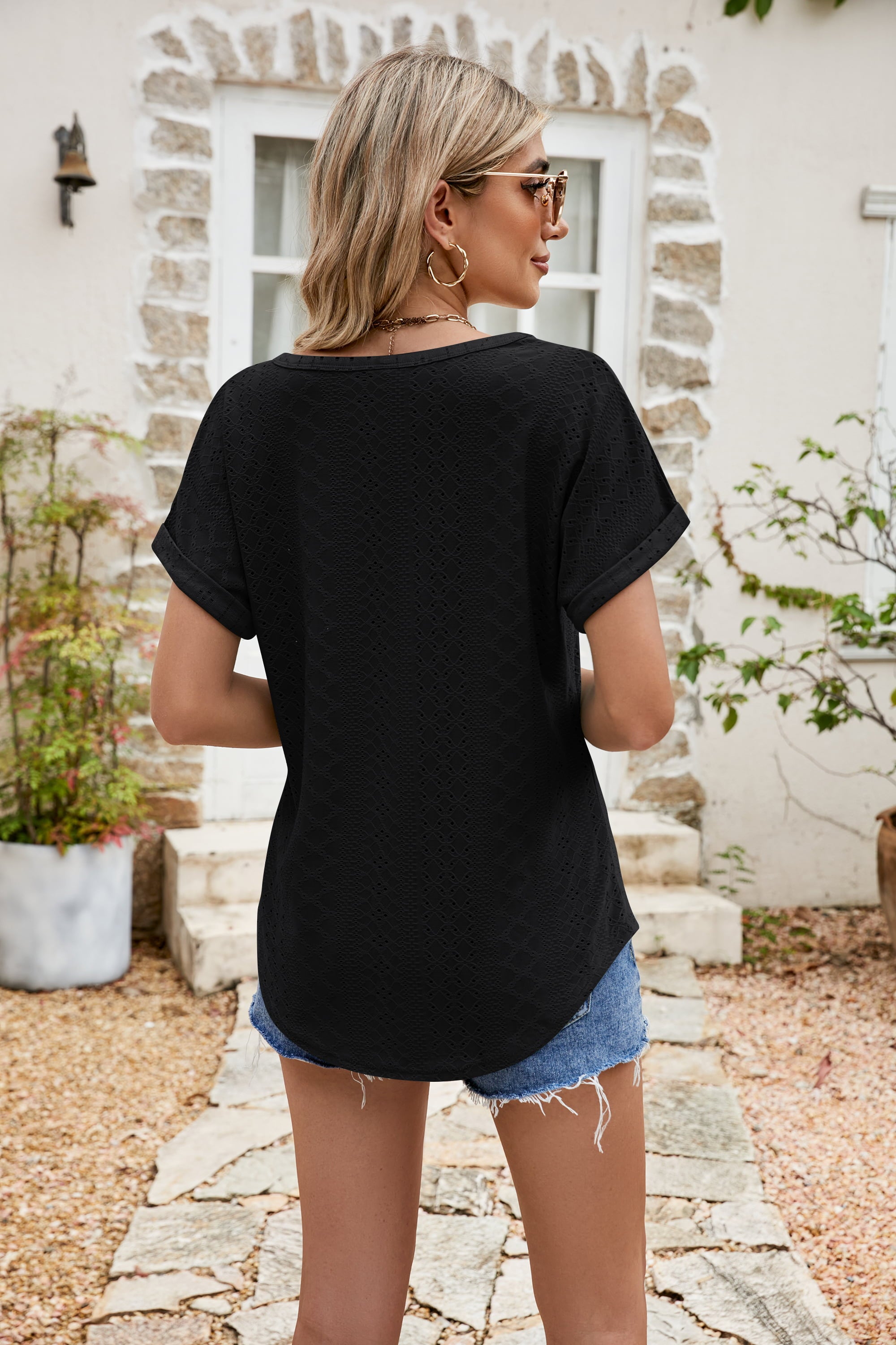 Black perforated tee with rolled cuff short sleeves and a scoop neckline.