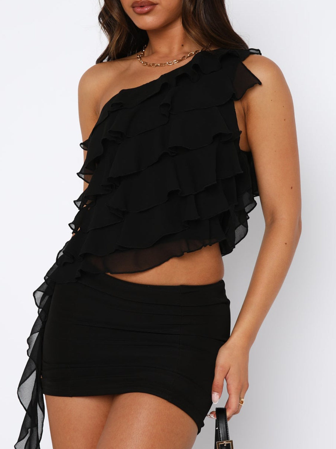 Black ruffled one-shoulder blouse with asymmetric cascading ruffles and a cropped hem.