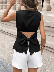Black blouse with cutout back and large bow detail.