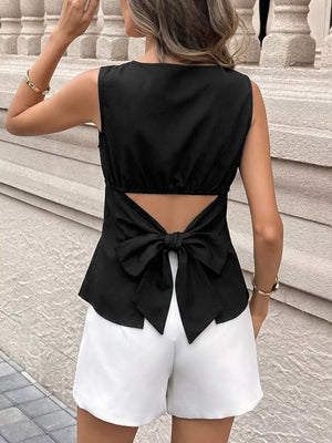 Black blouse with cutout back and large bow detail.