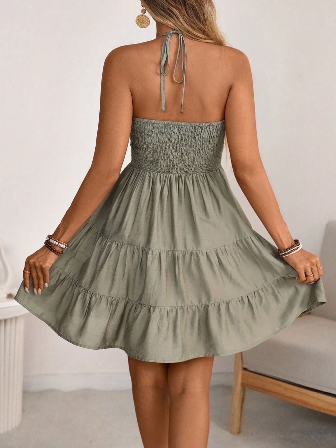 Olive ruched halter tiered mini dress with ruffles and a tie back.