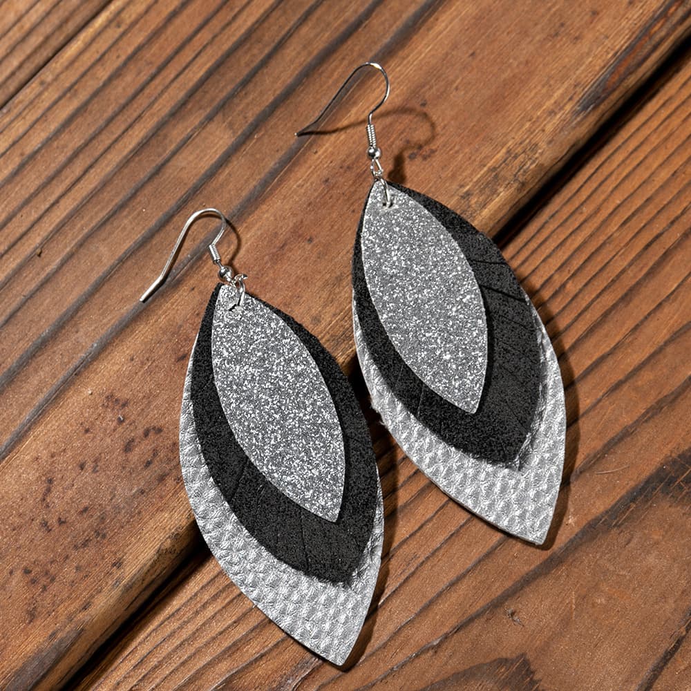 Layered faux leather statement earrings in silver and black with glitter detail.