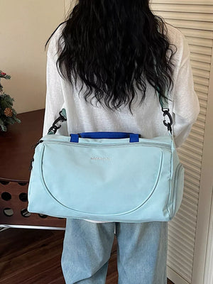 Light blue duffle bag with adjustable strap and blue handles, embroidered logo.