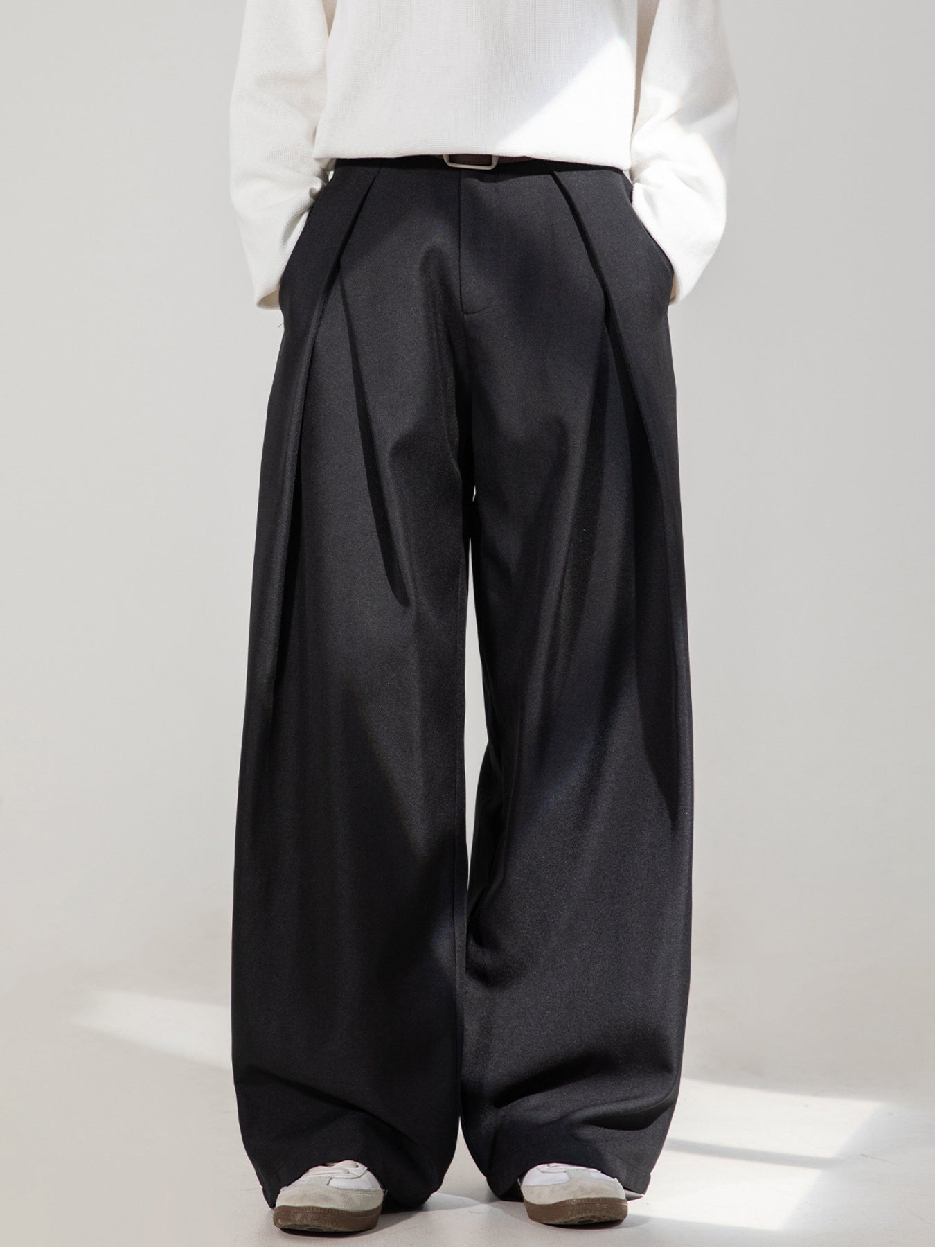 Men's black wide-leg trousers with pleats and a belt.