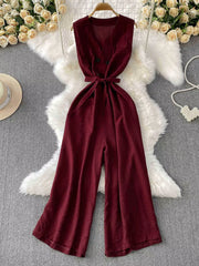 Burgundy V-neck wide leg jumpsuit with tie belt and double button detail.