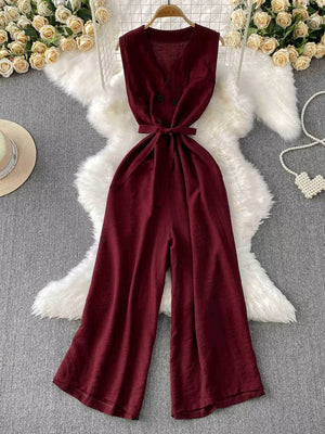 Burgundy V-neck wide leg jumpsuit with tie belt and double button detail.
