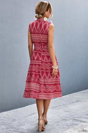 Deep Red sleeveless midi dress with geometric print, A-line cut, and tiered skirt.