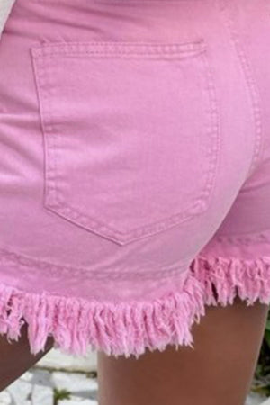 Pink denim shorts with high rise and frayed hem detail.