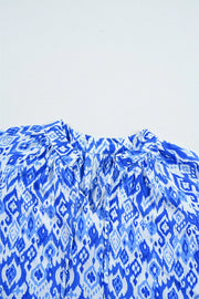 Royal blue ikat print V-neck blouse with tie detail and gathered neckline.