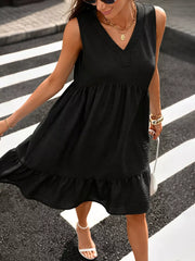 Black V-neck sleeveless dress with ruffle hem and textured fabric.