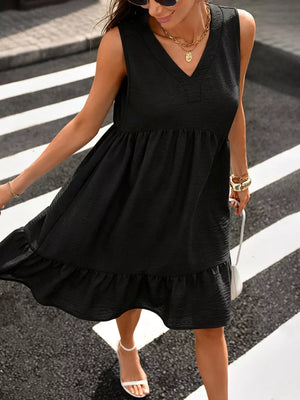 Black V-neck sleeveless dress with ruffle hem and textured fabric.