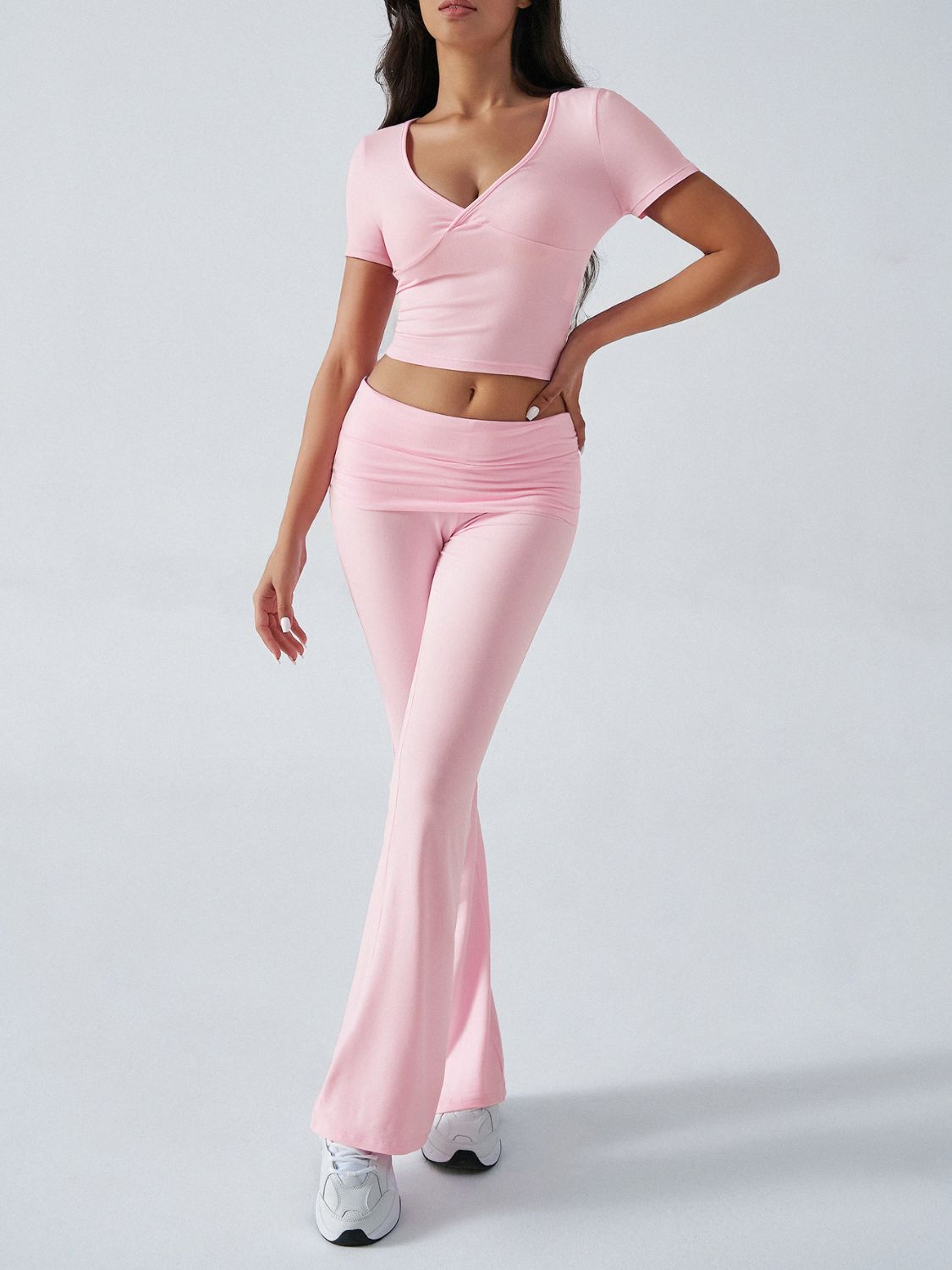 Blush pink loungewear set with ruched waistband flared pants and a V-neck wrap top.