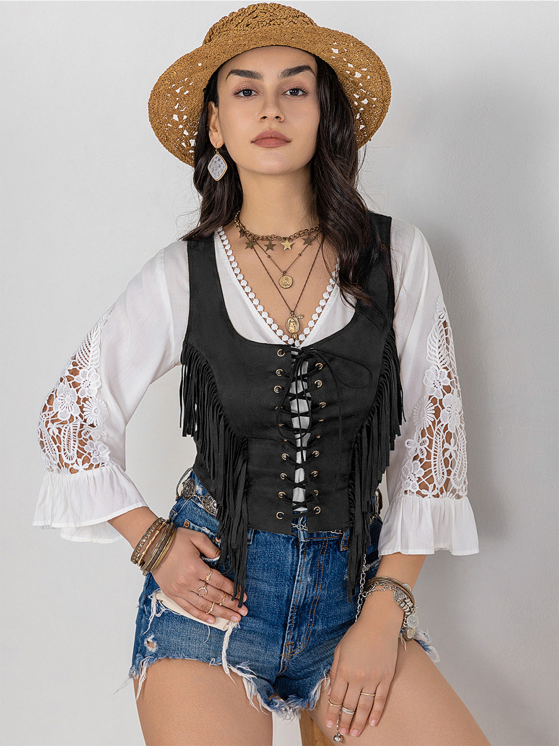 Black suede fringe corset vest with lace-up front detail and boho styling.