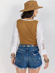 Tan suede corset vest with white lace sleeves, styled with denim shorts.