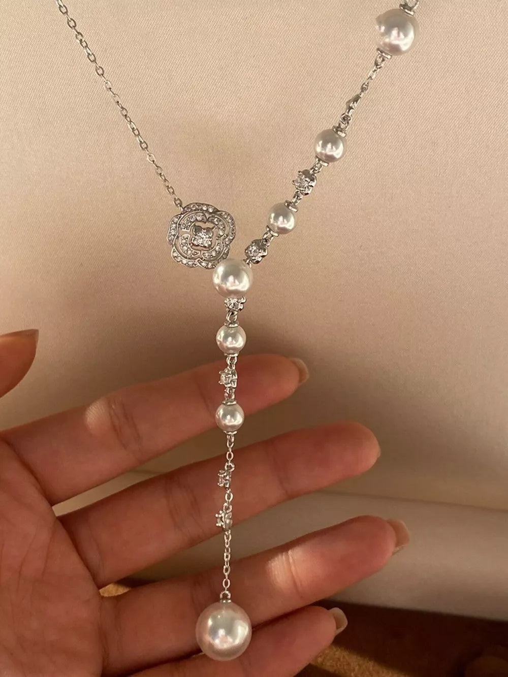 White pearl Y-necklace with a floral crystal pendant and scattered pearls.