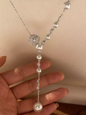 White pearl Y-necklace with a floral crystal pendant and scattered pearls.