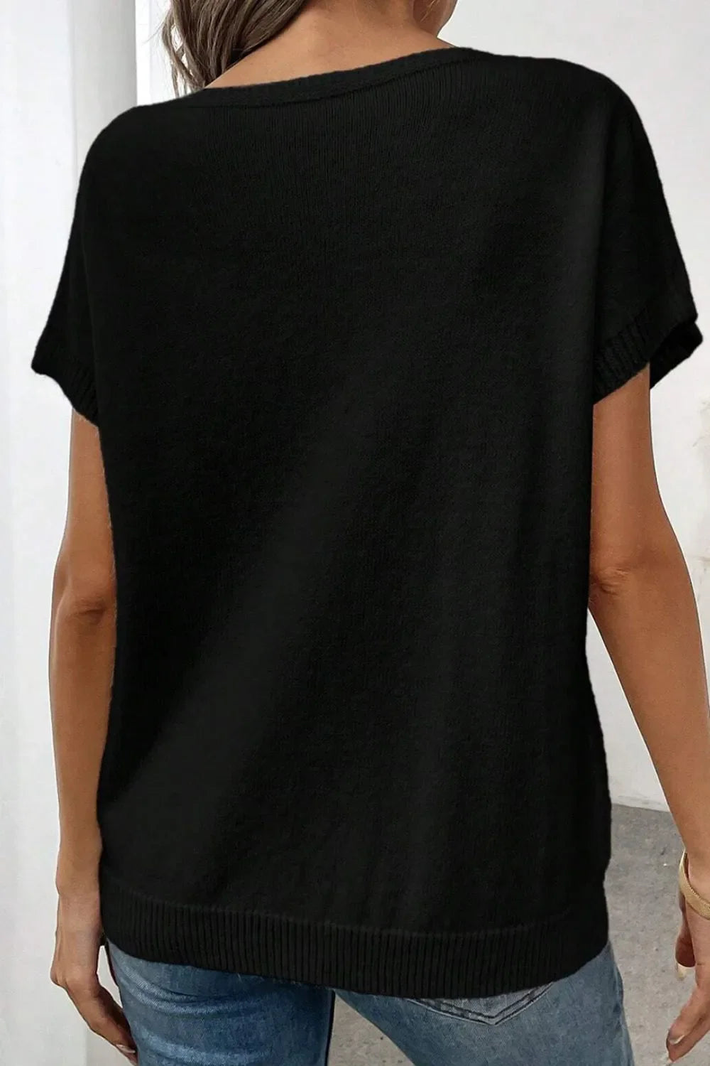 Black knit tunic t-shirt with short sleeves and a ribbed hem.