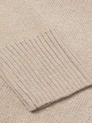 Tan knit sweater with ribbed trim detail on cuff.