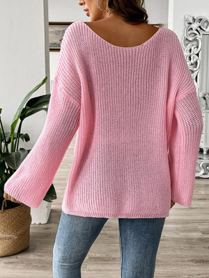 Blush pink knit sweater with boatneck and long sleeves, featuring a textured knit pattern.