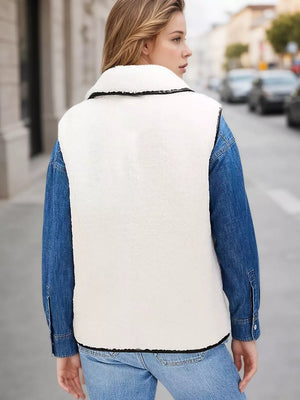 Cozy white sherpa vest coat with black contrast trim, worn over a denim shirt.