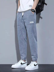 Light wash denim joggers for men with drawstring and patch detail.