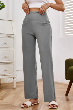 Gray high-waisted flare leg trousers with pockets, styled casually.