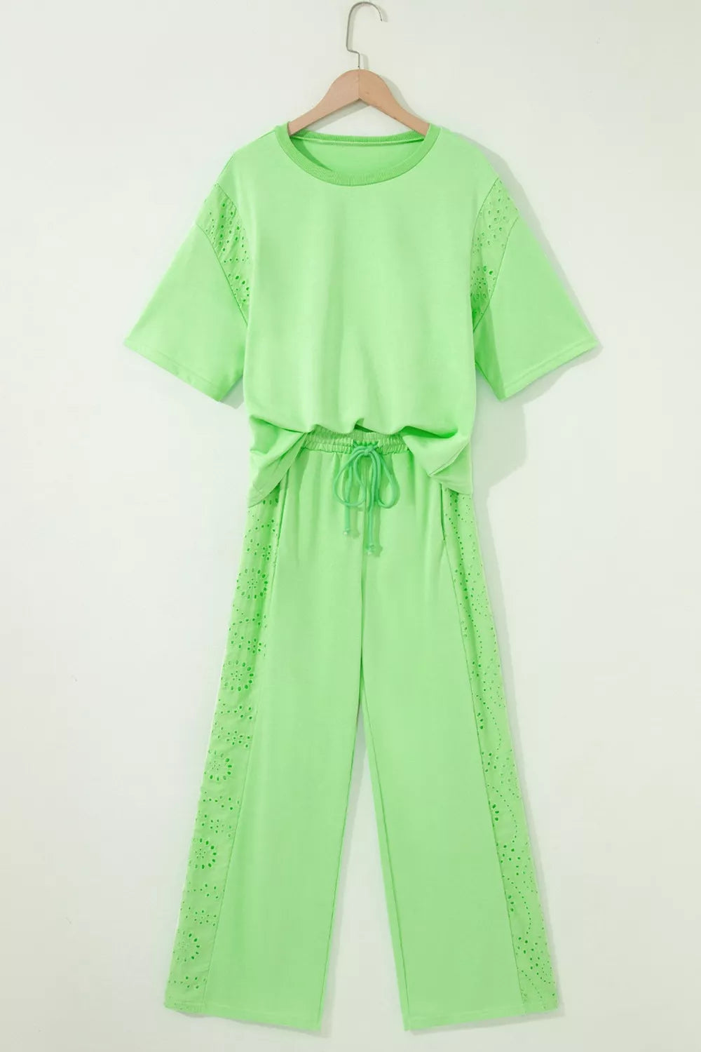 Lime green cotton two-piece set with embroidered eyelet details on the sleeves and pants, featuring a drawstring waist.