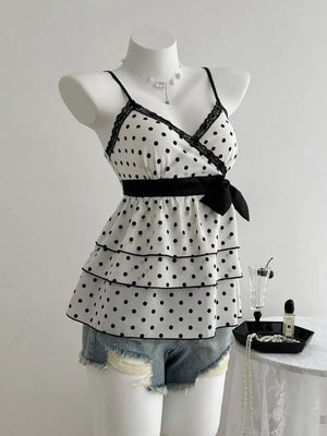 White polka dot camisole with black lace trim, tiered ruffles, and a black bow detail.