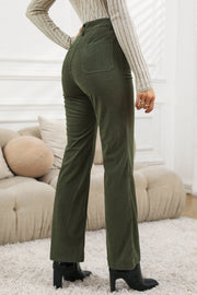 Olive corduroy flared leg trousers with back pockets, styled with a striped top and black boots.