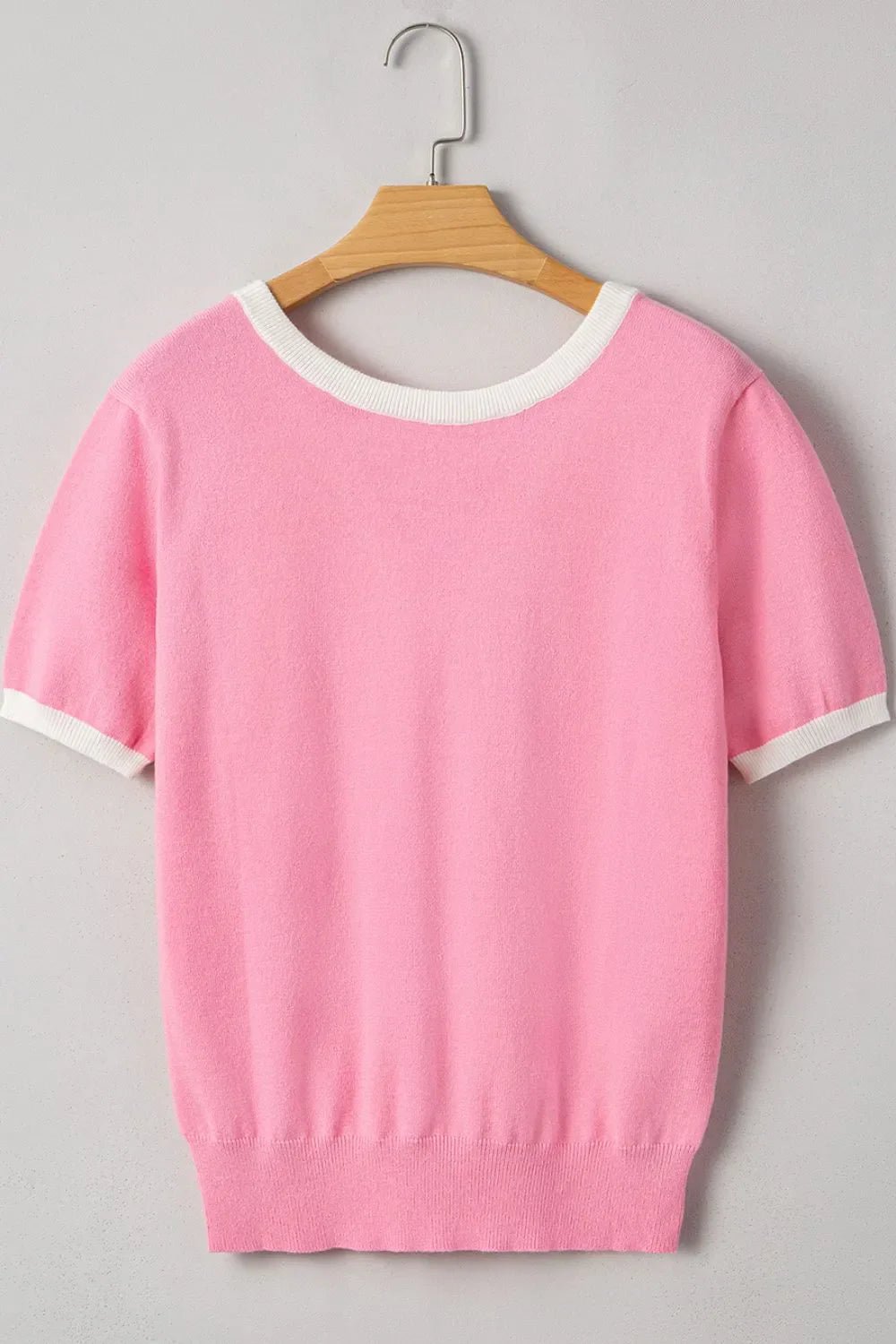 Pink knit top with white contrast trim on neckline and sleeves.