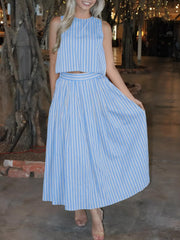 Buttoned two-piece set in sky blue and white vertical stripes, featuring a cropped top and midi skirt with pockets.