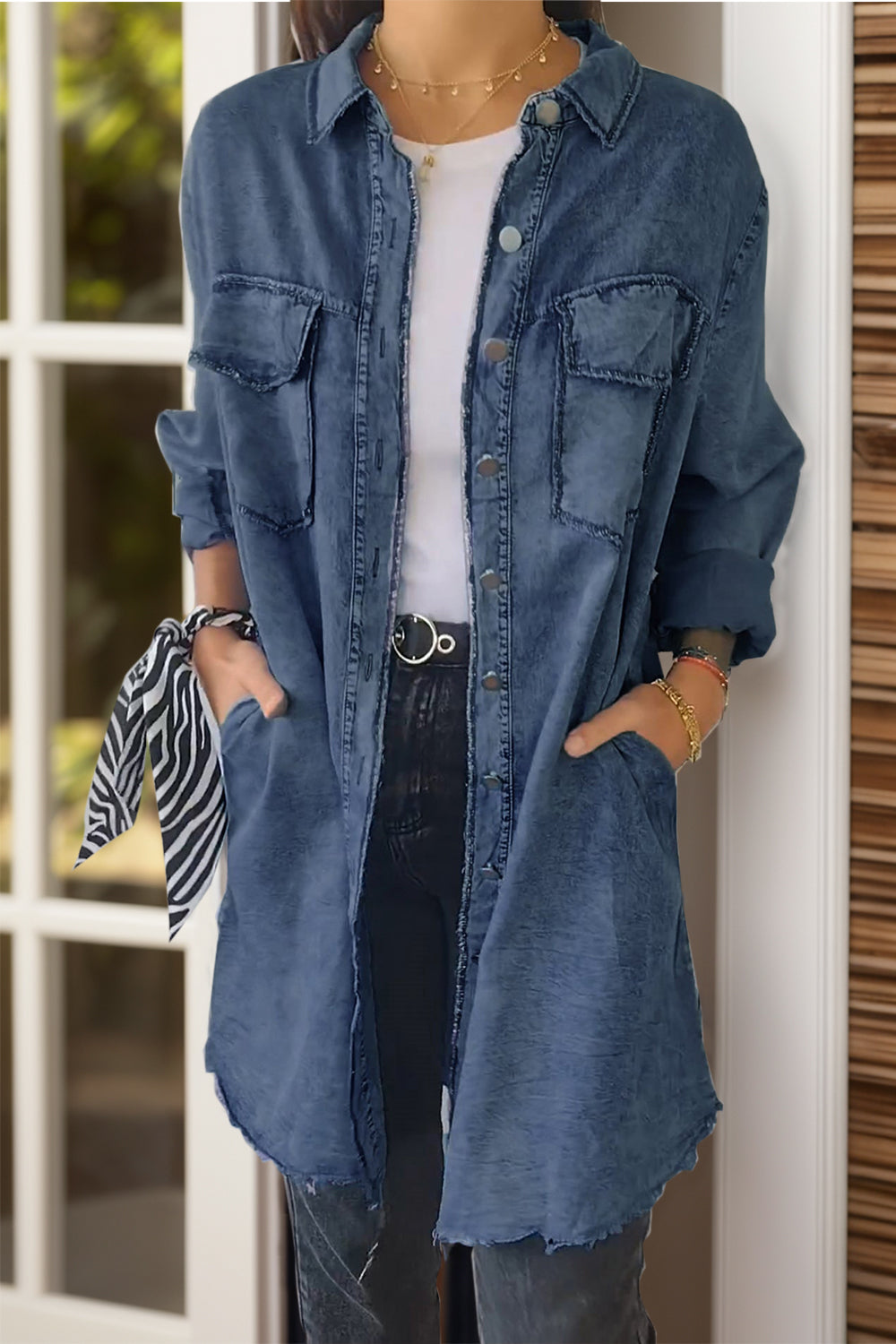 Oversized denim shirt jacket in light blue with buttoned front and chest pockets.