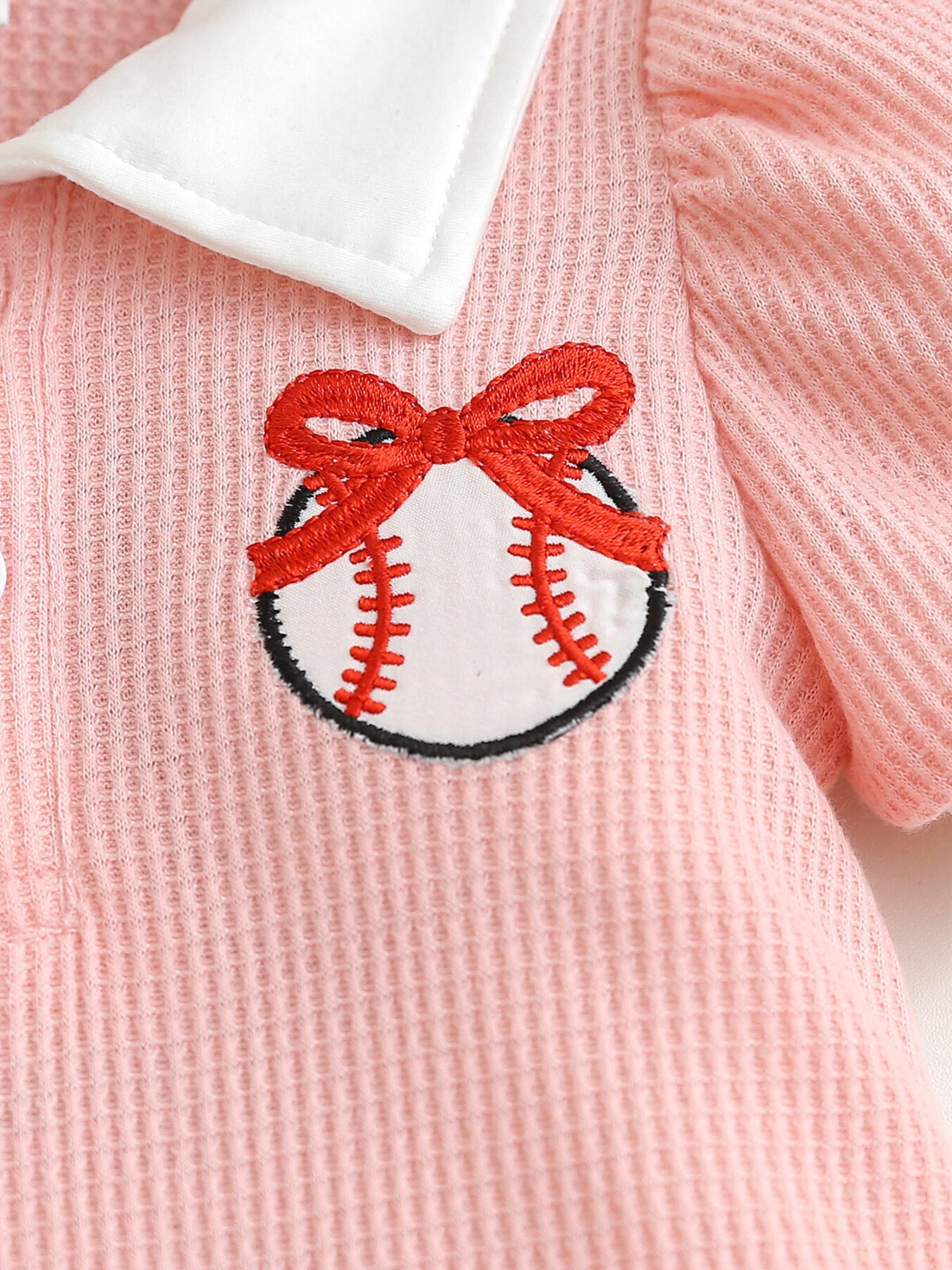 Pink waffle knit baby dress with white collar and embroidered baseball with red bow detail.