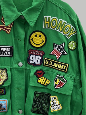 Green denim trucker jacket with embroidered patches including smiley face, U.S. Army, and "HONOY".