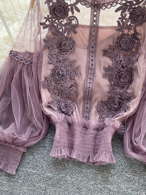 Purple lace blouse with floral embroidery and sheer puff sleeves, paired with a cami.