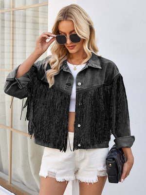 Black denim trucker jacket with fringe trim and button front, styled with white shorts.