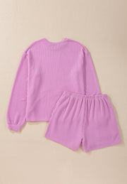 Pink textured loungewear set with a long sleeve top and shorts.