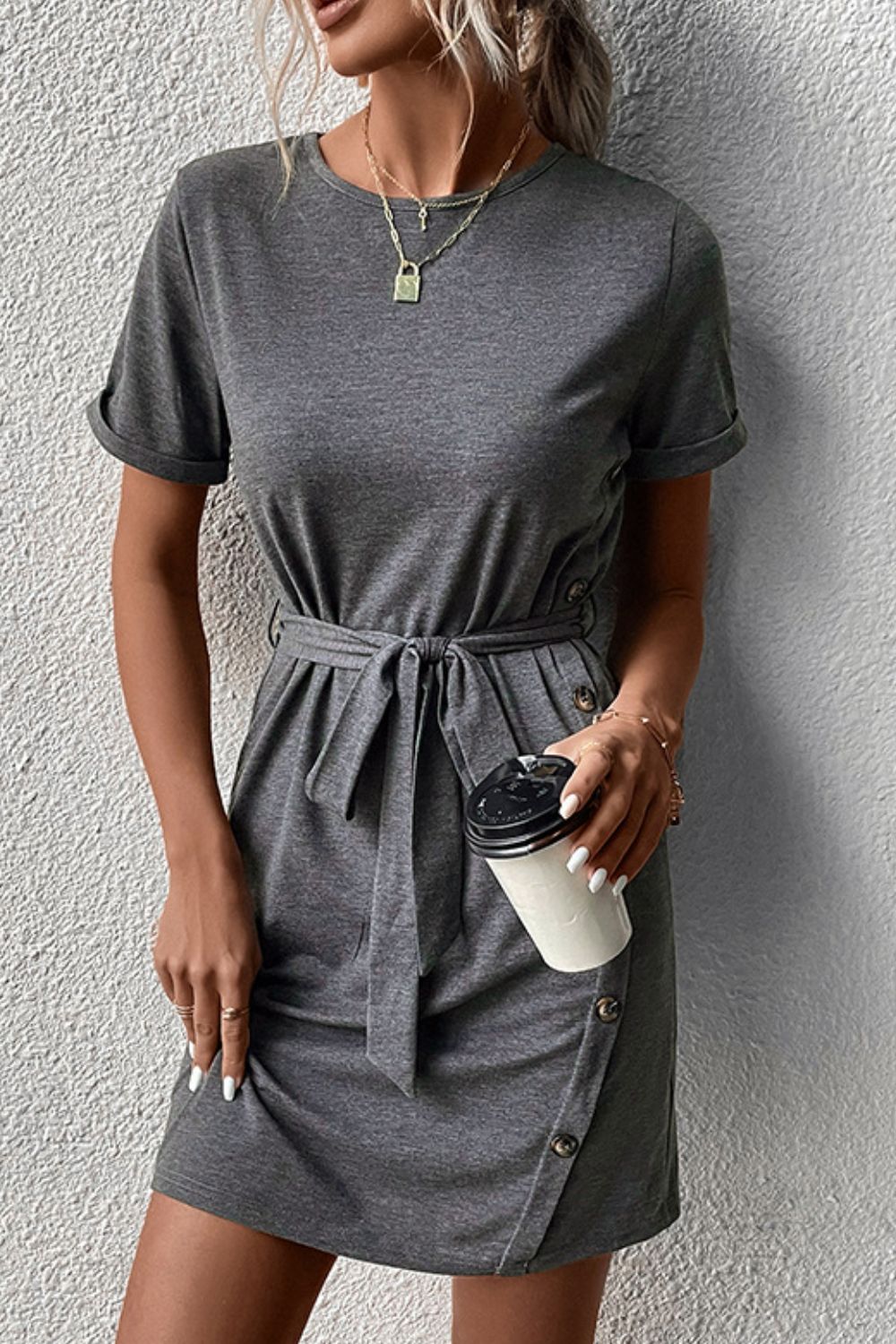 Dark gray tee dress with short sleeves, tie waist, and button detail on skirt.