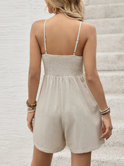 Beige linen romper with smocked back and adjustable spaghetti straps.