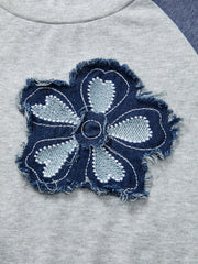 Raglan shirt with a distressed denim embroidered flower patch detail.