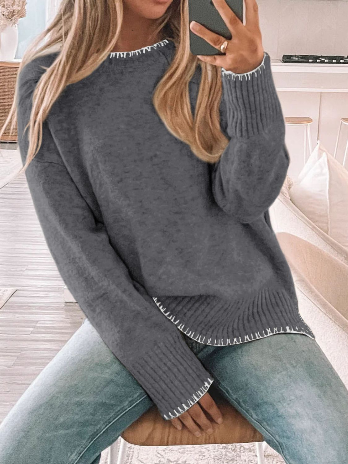 Dark gray crew neck sweater with contrast white stitching on neckline, cuffs, and hem