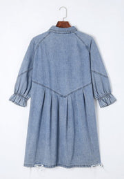 Light blue denim shirtdress with ruffled cuffs, A-line cut, and frayed hem.