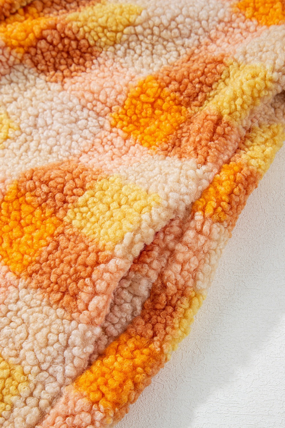 Checkerboard sherpa jacket in tangerine with a textured fuzzy fabric and a relaxed fit.