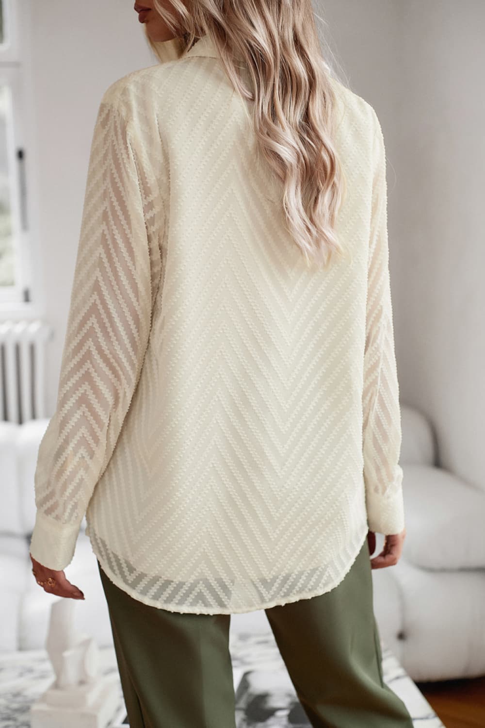 Ivory textured chevron button-down blouse with sheer sleeves.