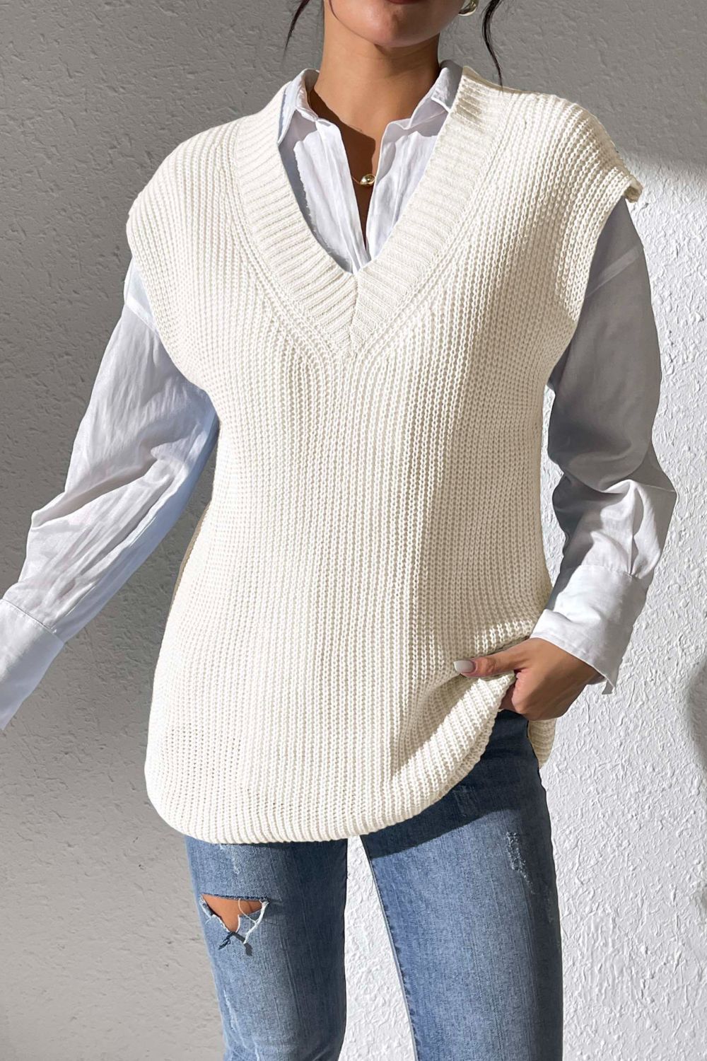 Ivory textured knit V-neck sleeveless top styled with a white shirt and jeans.