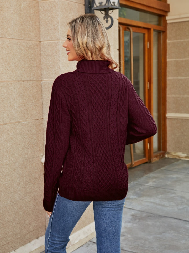 Cable knit turtleneck sweater in wine with detailed cable patterns.