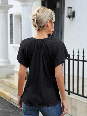 Black perforated tie-neck flutter sleeve blouse with a ruffled hem