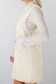 Cream sleeveless knit pocket dress with V-neck, styled over a ribbed turtleneck.