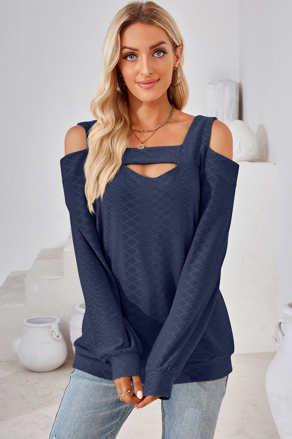 Dark blue textured top with cutout neckline and cold shoulder long sleeves.