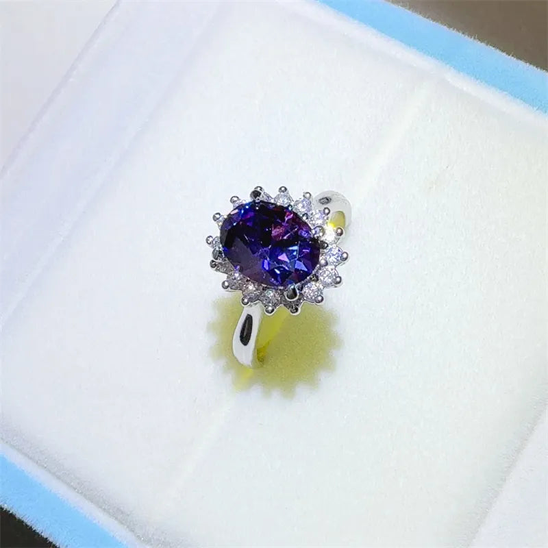 Amethyst sunburst moissanite ring in silver with halo of small diamonds.